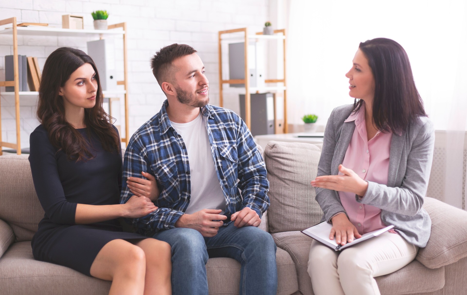 Consulta de pareja en un entorno de oficina moderno con un consejero que discute la dinámica de la relación