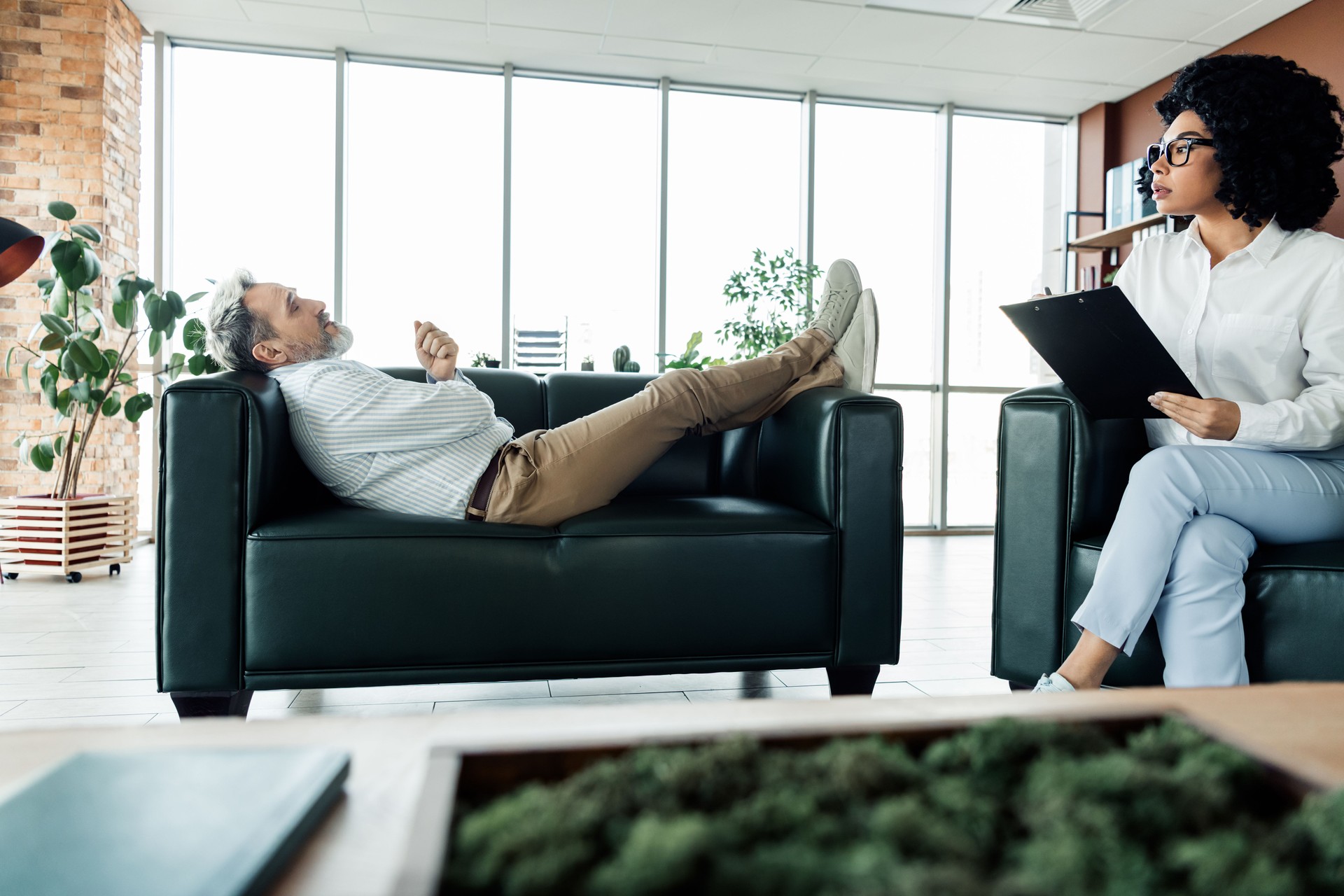 Sesión de terapia profesional en un entorno de oficina moderno con un ambiente relajado centrado en la colaboración y la asistencia